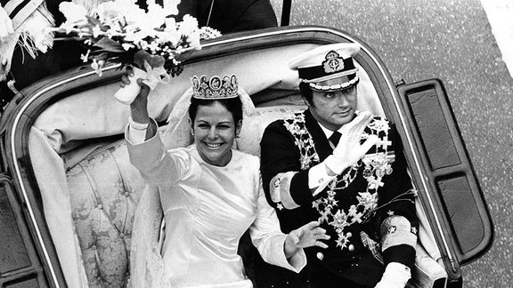Schwedens König Carl Gustaf und Königin Silvia fahren während ihrer Hochzeit 1976 in einer offenen Kutsche durch Stockholm.