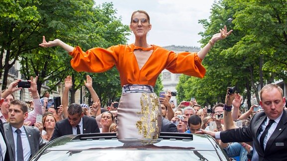 Celine Dion beim Verlassen des Royal Monceau Hotels in Paris, in einem Cabrio stehend, von Fans gefeiert und bejubelt