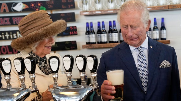 Prinz Charles reagiert auf ein schlechtes Bier, das er in der Quidi Vidi Brauerei gebraut hat, während Herzogin ihm Camilla zusieht.