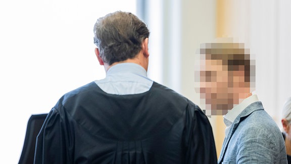 Der Angeklagte Christian B. (r) steht vor Prozessbeginn im Gerichtssaal im Landgericht Braunschweig.