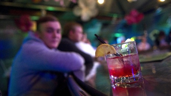 Ein Cocktail steht auf einem Thresen.
