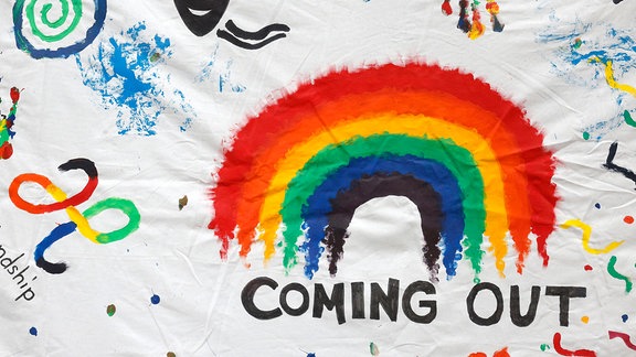 Der Schriftzug Coming Out mit einem Regenbogen