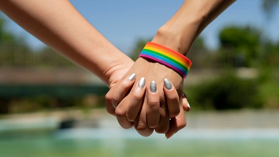 vereinte Hände der Frau mit lgtbi Armband
