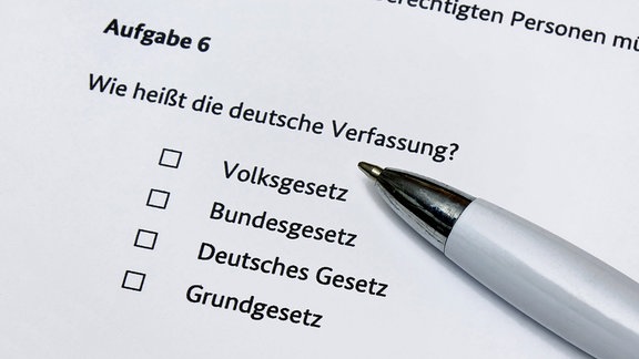 Fragenkatalog zum Einbürgerungstest und Kugelschreiber