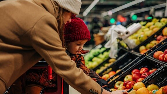 Mutter mit Kind in der Obstabteilung eines Supermarktes