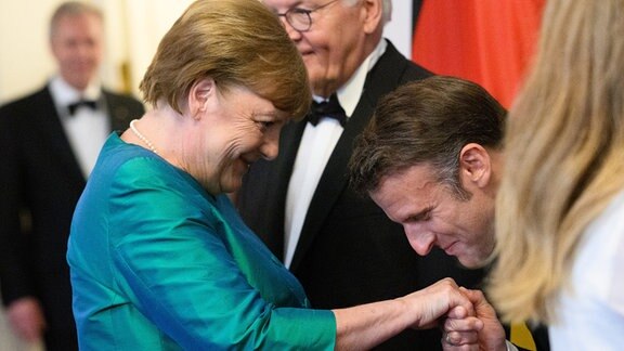 Angela Merkel (CDU), Bundeskanzlerin a.D., wird beim Defilee vor dem Staatsbankett von Emmanuel Macron, Präsident von Frankreich, im Schloss Bellevue begrüßt