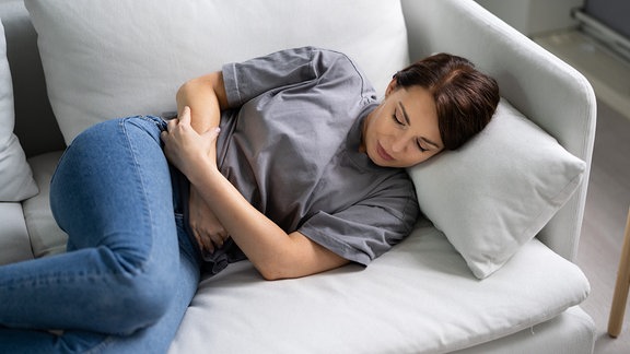 Eine junge Frau liegt auf einem Sofa