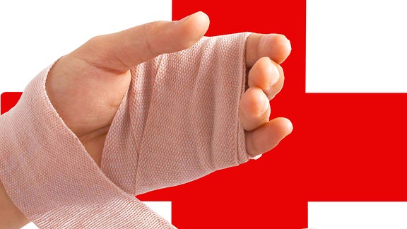 Eine verbundene Hand vor einem roten Kreuz