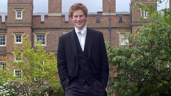 Prinz Harry trägt die Schulkleidung, die aus einem schwarzen Frack und einer schwarzen Weste sowie einer Hose mit Nadelstreifen besteht.