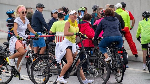 Fahrradfahrer fahren vor der offiziellen Eröffnung durch den Straßen-Tunnel unter der Swine (Świna) in Swinemünde (Świnoujście).