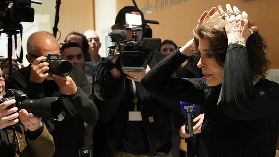 Die Schauspielerin Fanny Ardant ist von Pressefotograf*innen umringt.