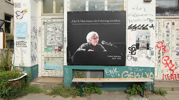 An der Fassade eines Hauses hängt ein Plakat mit dem Konterfei von Esther Bejarano