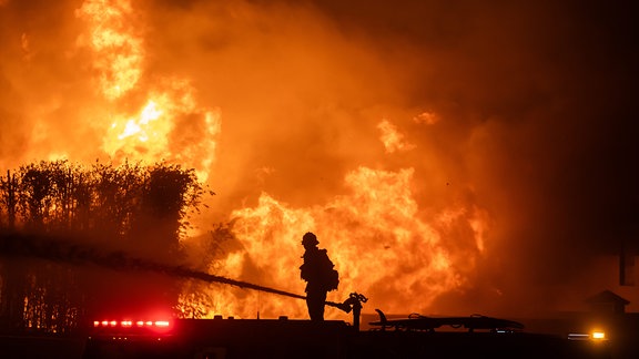 Feuerwehrmann bekämft auf einem Feuerwehrfahrzeug Feuer