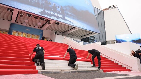 Ein roter Teppich wird auf einer Treppe verlegt