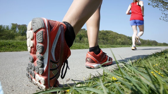 Junge Frauen, 25-30 Jahre alt, joggen, Laufschuhe. Freizeitläuferin.