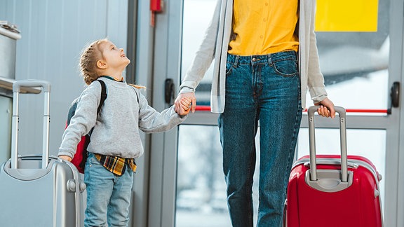 Mutter und Tochter mit Reisegepäck auf dem Flughafen