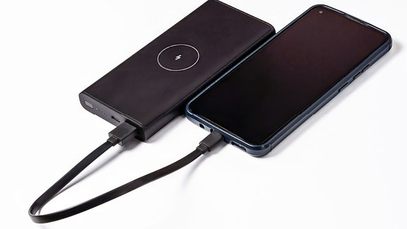Ein Smartphone hängt zum Laden an einer Powerbox