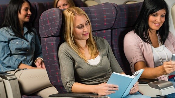 Zwei Frauen lesen im Flugzeug