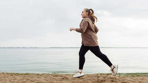 Frau joggt am Strand