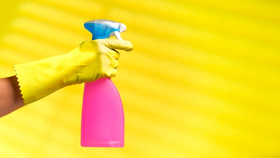 Eine Frau hält eine Sprühflasche