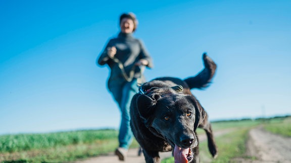 eine Frau läuft mit ihrem Hund