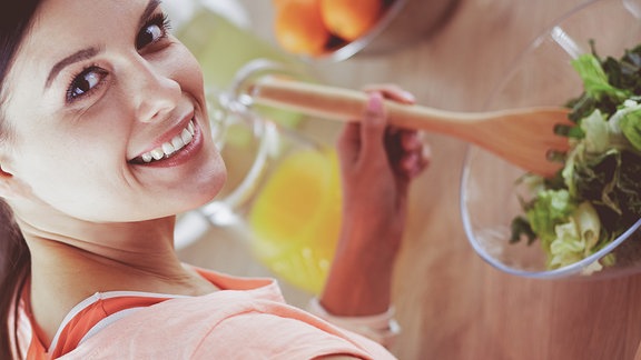 Eine junge Frau macht einen Salat