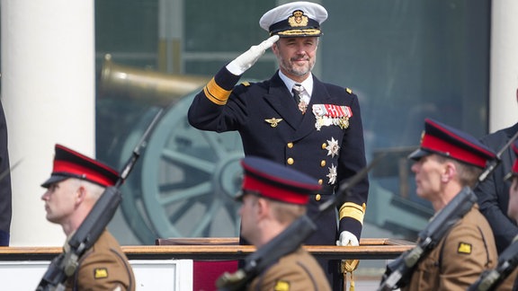 König Frederik salutiert in Uniform bei einer Militärparade.