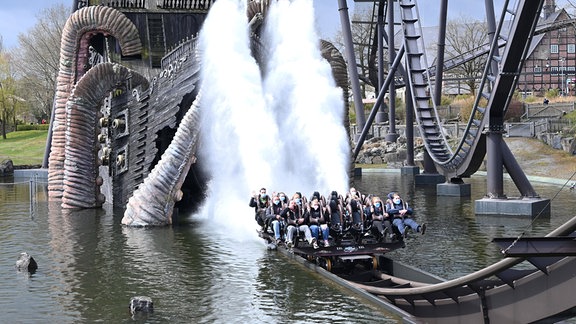 Gäste in einem Fahrgeschäft in einem Freizeitpark.