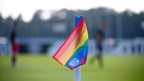 Eine Regenbogenfahne weht am Spielfeldrand.