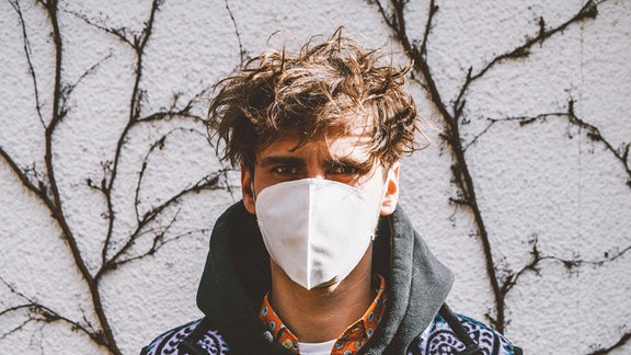 Influencer Fynn Kliemann präsentiert einen Mundschutz seiner Produktion. 