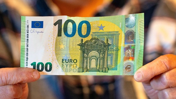 Hände halten einen 100-Euro-Schein