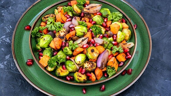 Ein warmer Salat mit gegrilltem Gemüse, auf einem Teller angerichtet.