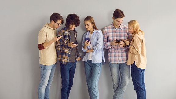 Gruppe junger Menschen, die auf ihr Smartphone schaut