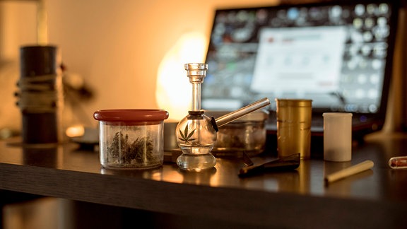 Marihuana im Glas, Haschpfeife, Joint auf einem Tisch