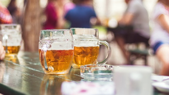 Biergläser auf Tisch in Gartenrestaurant