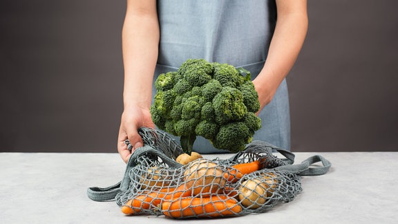 Person packt Gemüse aus einem Beutel