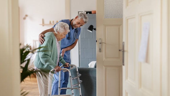 Arzt und ältere Frau in einem Pflegeheim mit Rollator