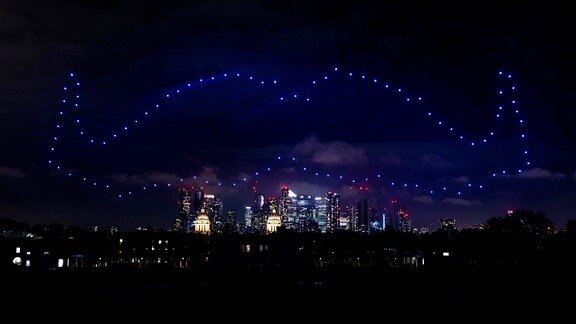 100 Drohnen in einer Formation in Form eines Schnurbartes am Himmel über dem Londoner Greenwich Park zur Feier des 20-jährigen Jubiläums der weltweiten Wohltätigkeitsorganisation für Männergesundheit.
