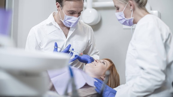 Zahnarzt gibt Patientin Spritze