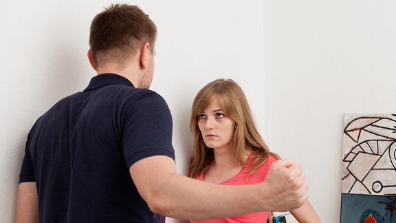 Mann bedroht Frau mit erhobener Faust
