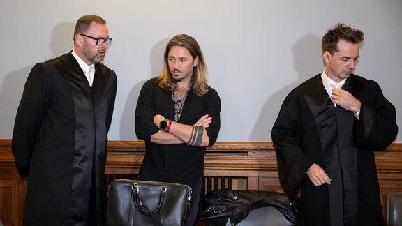 Der deutsche Rockmusiker Gil Ofarim (M) steht im Saal des Landgerichts in Leipzig zwischen seinen Anwälten.