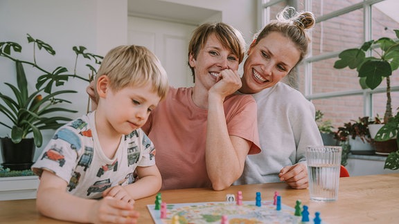 Zwei Frauen und ein Junge bei einbem Brettspiel