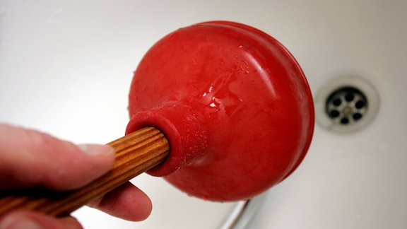 Ein Verstopfter Abfluss in der Badewanne wird mit Glockensauger bearbeitet