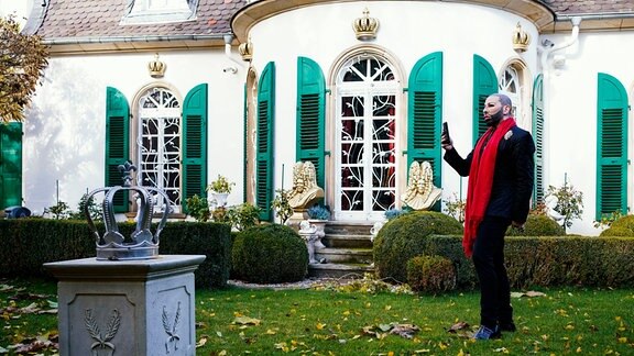 Harald Glööckler, Modedesigner und Unternehmer, steht im Garten seines Anwesens.