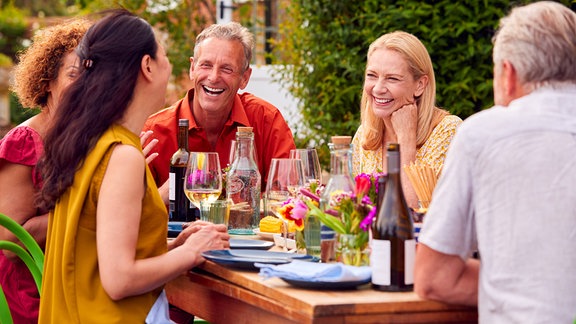 Menschen lachen bei einer Gartenparty