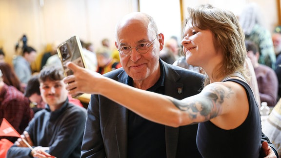 Der Bundestagsabgeordnete Gregor Gysi (l) macht mit einer Parteigenossin ein Selfie beim Politischen Aschermittwoch der Linke in Thyrnau-Kellberg.