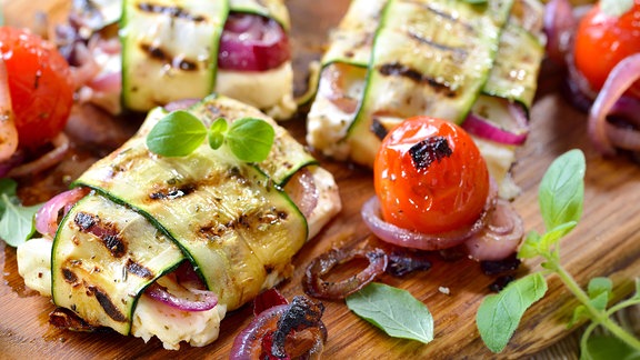 griechische Feta-Zucchini-Päckchen mit Zwiebeln und Kräutern sowie Grilltomaten 