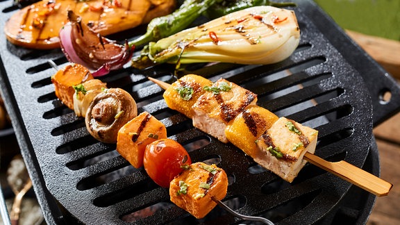 Gemüsespieße auf einem Grill über heißen Kohlen.
