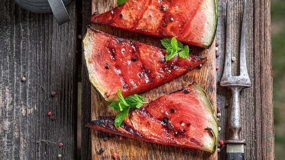 Leckere gegrillte Wassermelone auf dem Grillrost mit Feuer.