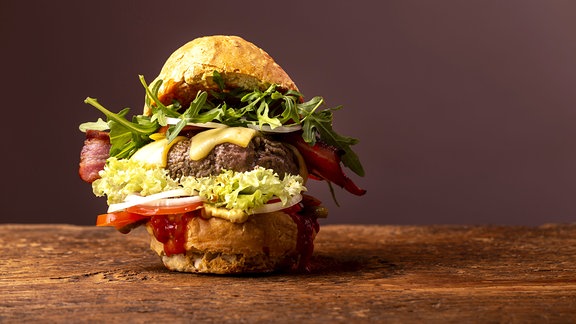 einzelner Hamburger auf dunklem Holz